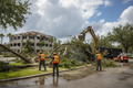 Crew clearing storm debris and downed trees from commercial property